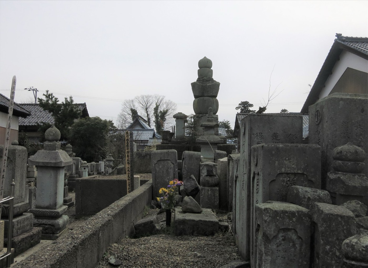 五輪塔と石塔が並ぶ寺院墓地の現代の写真